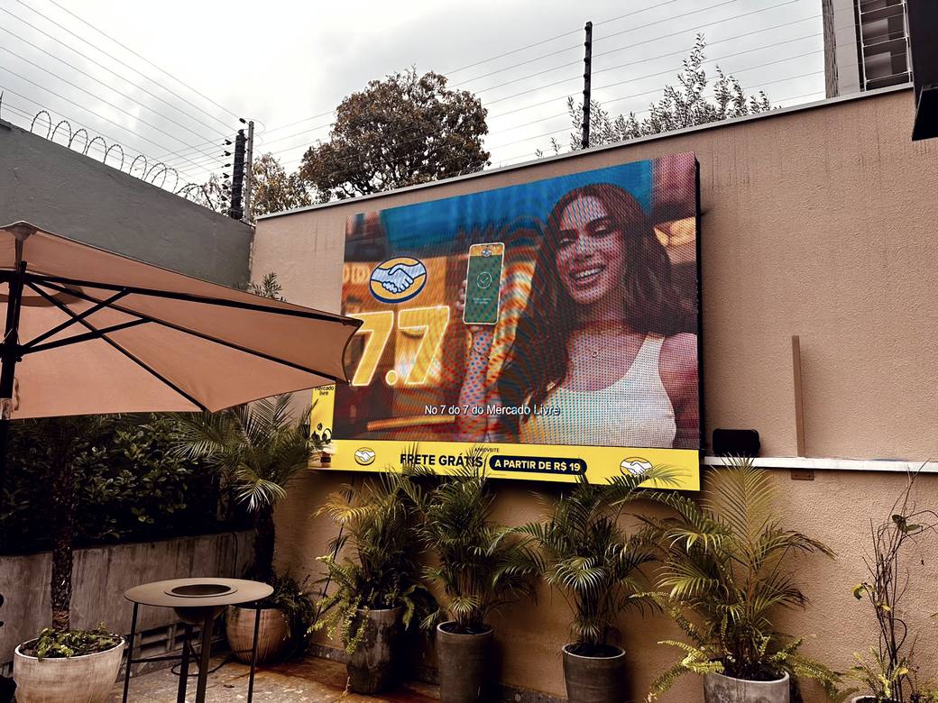 Telão LED na área externa de um bar exibindo um anúncio